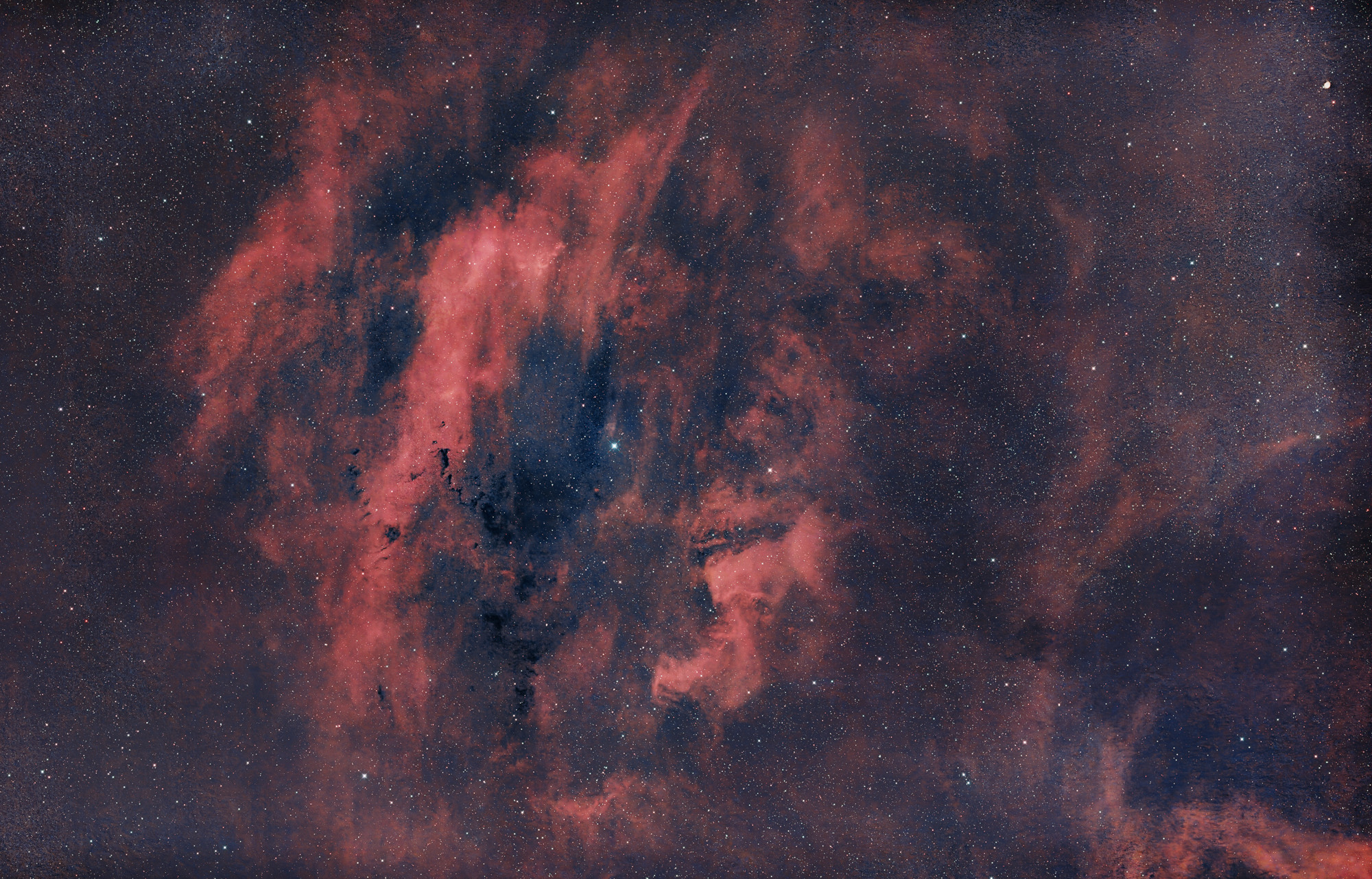 Sharpless 119 is an emission nebula in the constellation Cepheus and is illuminated by the hot blue giant 68 Cygni. Along the southern border - in this view at the bottom left - several dark nebulae from the Lynds Dark Nebulae (LDN) catalog are visible.